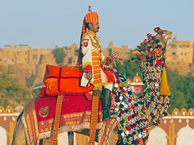 "Jaisalmer, Rajasthan, India - February 20, 2008: Uniformed officer of the Border Security Force rides a decorated camel in front of Jaisalmer Fort as part of the Desert Festival held annually in Jaisalmer, Rajasthan, India. The Border Security Force were established to patrol the desert border between India and Pakistan and do so using camels."